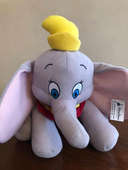Disney Dumbo the Flying Elephant plush toy with a Disney Parks tag on its left ear.
